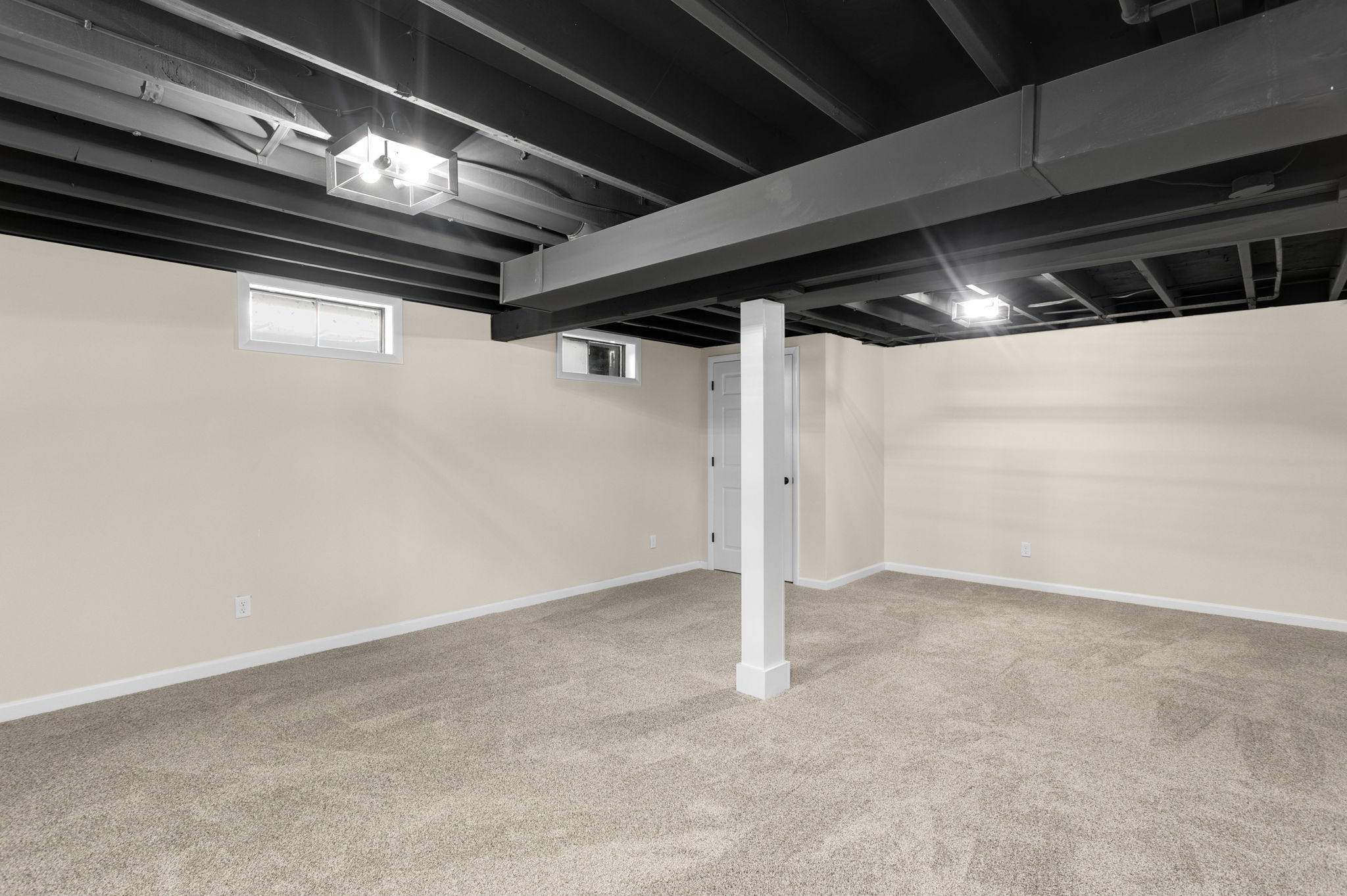 After: Finished basement with painted black joists and new carpet — 15278 Montecito Granger