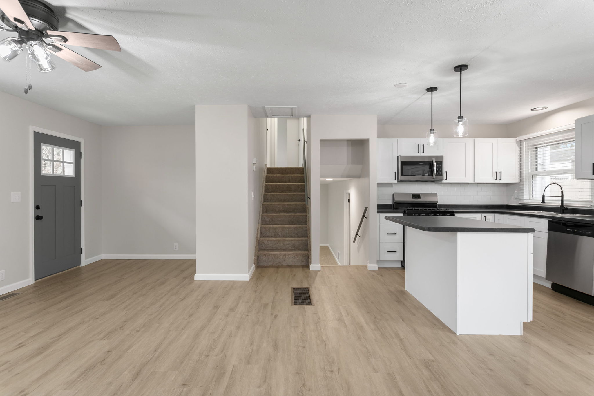 After: Open living area and kitchen with new LVP flooring — 4334 Coral South Bend