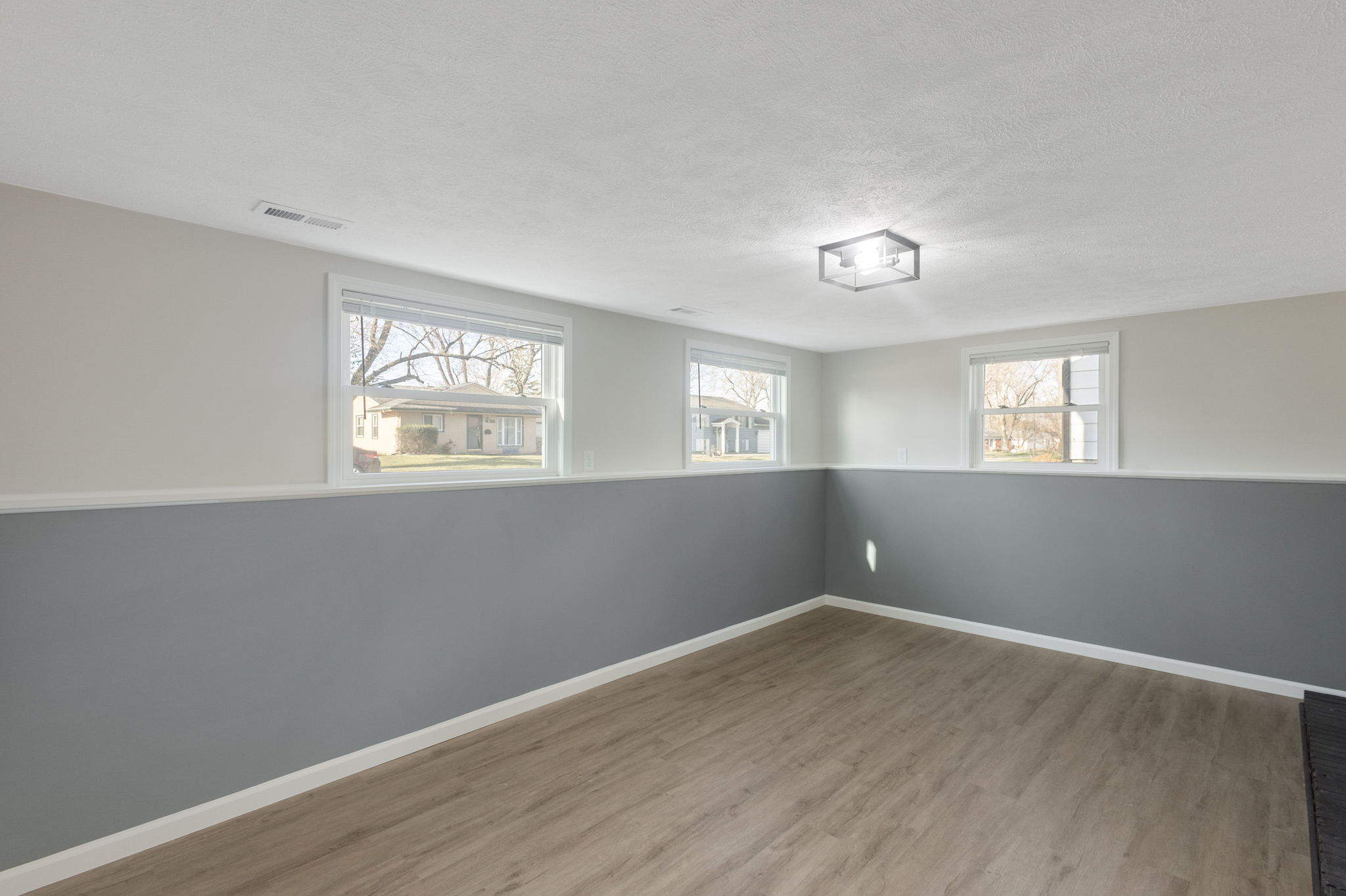 After: Lower level living area with two-tone accent wall and new LVP โ 4920 Blackford South Bend