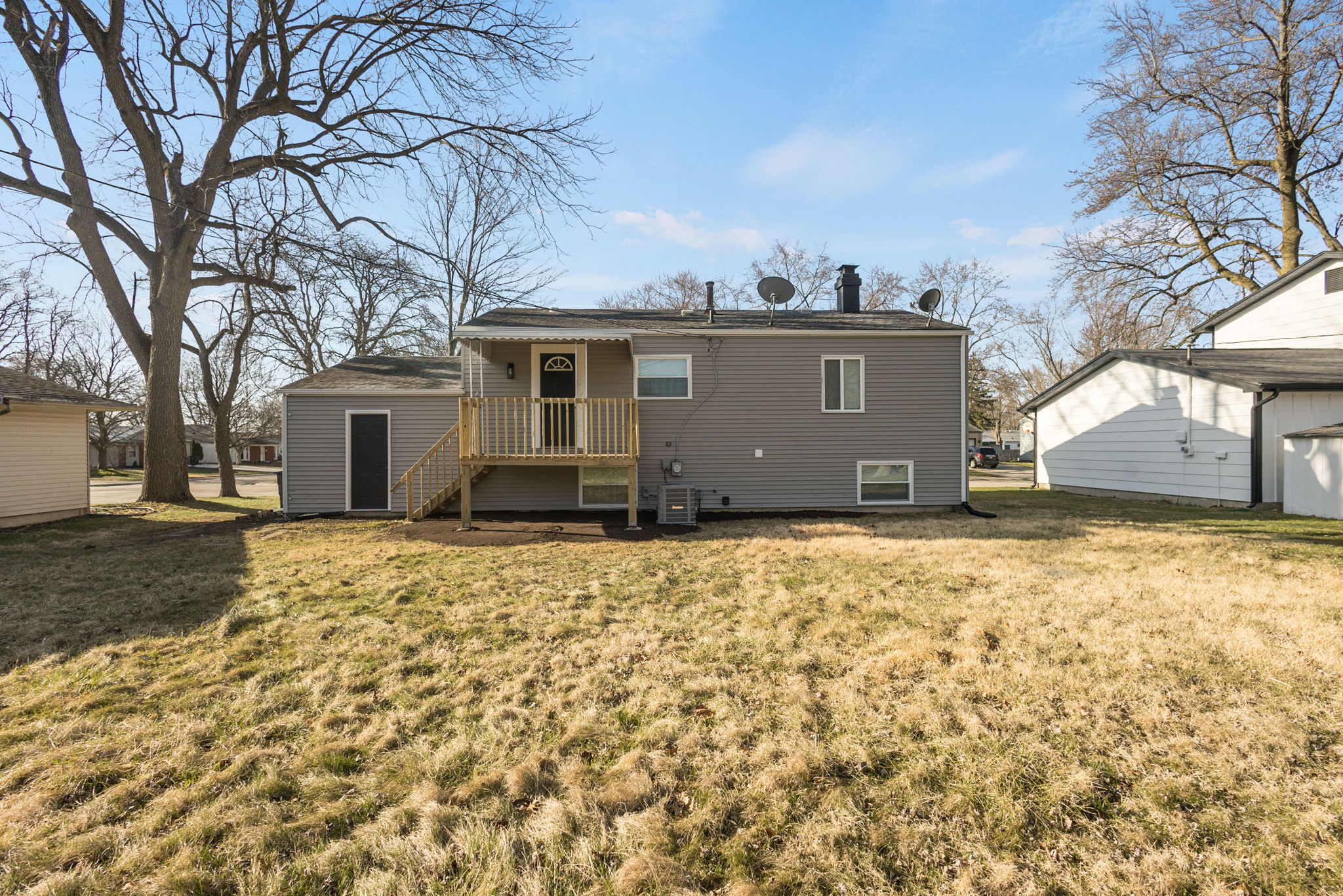 After: Rear exterior with new siding, deck, and HVAC โ 4920 Blackford South Bend